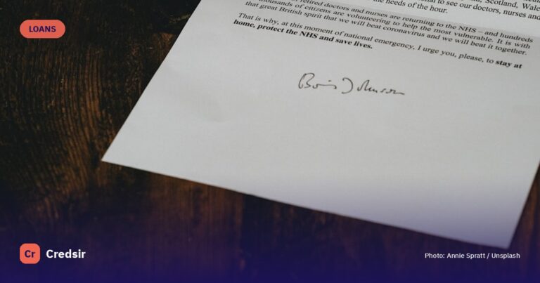 White printer paper on brown wooden table — cover photo for Credsir’s Car Loan guide