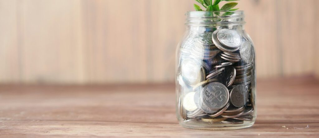 A glass jar filled with coins and a plant